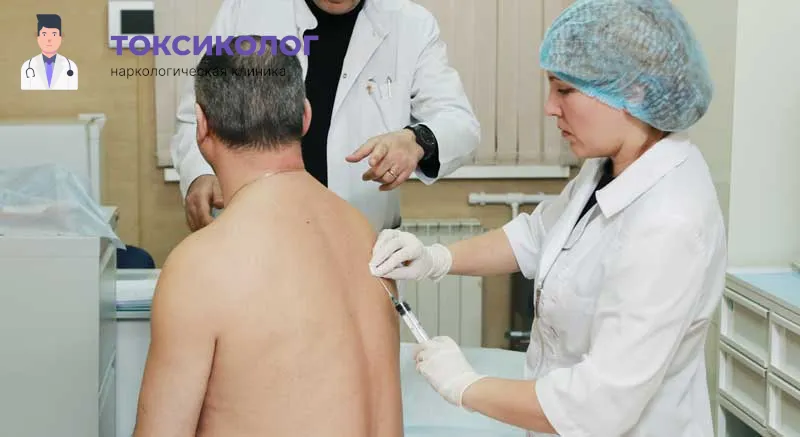 Врач клиники Токсиколог делает подкожную инъекцию пациенту в спину в рамках процедуры кодирования Эспераль.